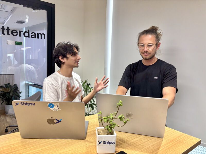 Two Shipsy team members collaborating at their laptops