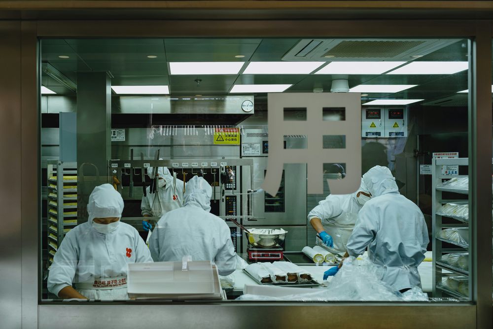 Gowned operators in a controlled pharmaceutical facility